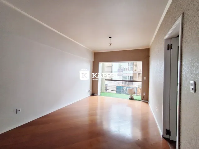 Sala de estar ampla com piso de madeira clara e acesso a uma área externa.