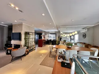 Sala de estar e jantar moderna com piso de porcelanato claro.