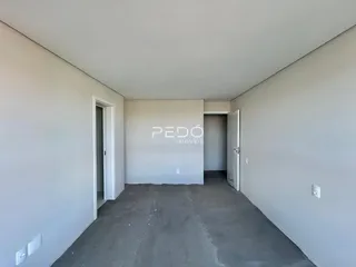 Imagem de um espaço interno com paredes brancas e piso de concreto.