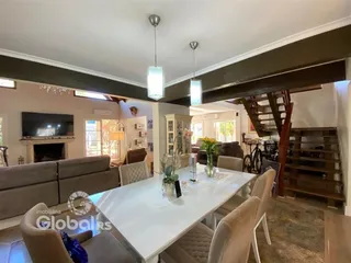 Sala de estar com mesa de jantar e lareira em um imóvel no Brasil.