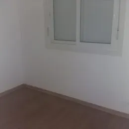Foto de uma parede branca com uma janela.
