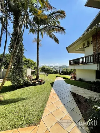 Vista da fachada de uma casa com jardim e calçada.
