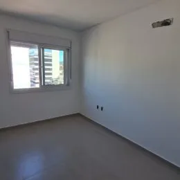 Foto de um cômodo interno com paredes brancas e uma janela.