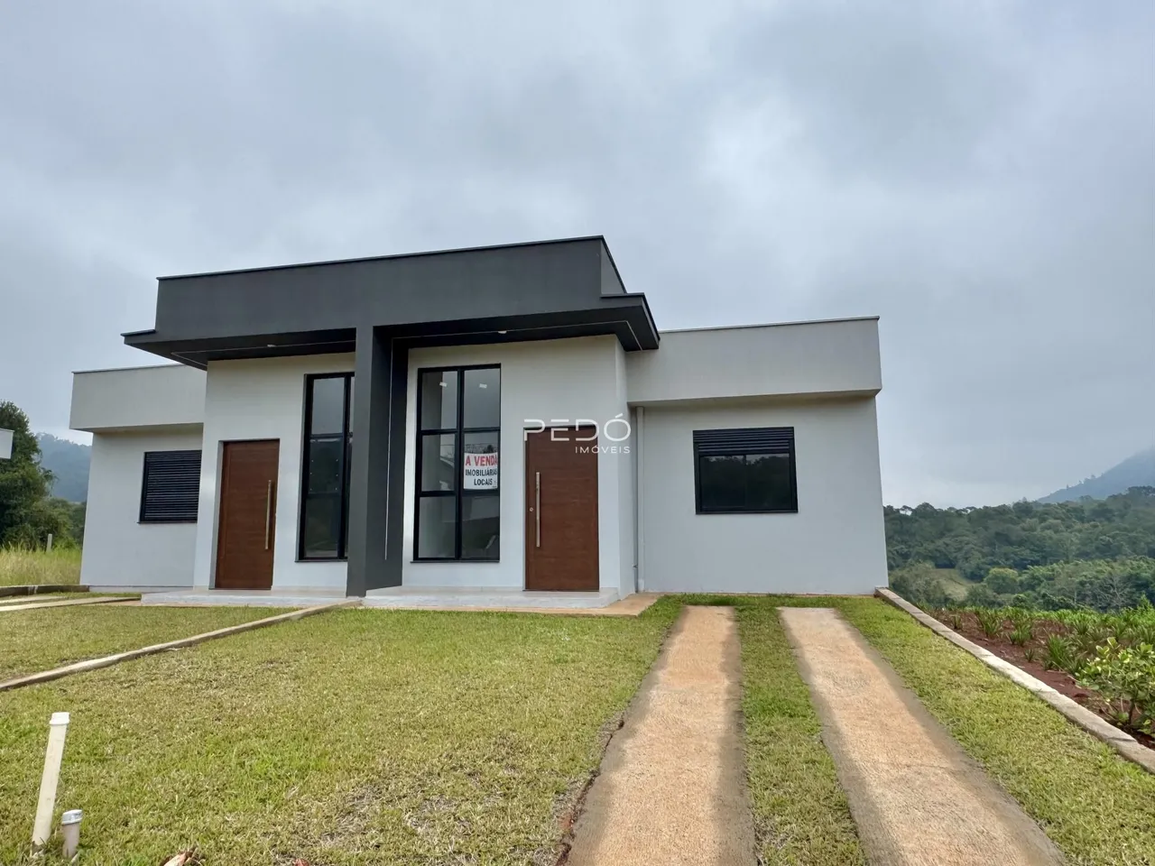 Fachada moderna de uma casa em Lajeado, Brasil, com jardim frontal.