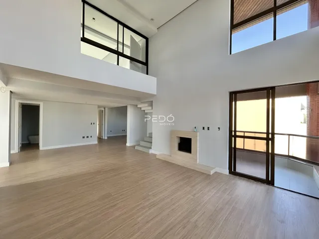 Ambiente amplo com piso de madeira clara e paredes brancas.