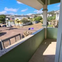 Vista da varanda externa do imóvel em Lajeado, com vegetação ao fundo.