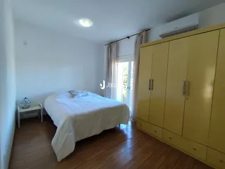 Quarto com cama e guarda-roupa amarelo em um imóvel no Brasil.