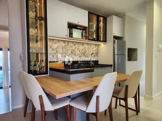 Vista de uma sala de jantar com mesa de madeira e cadeiras em um imóvel no Brasil.