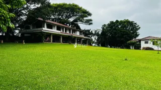 Fachada de uma casa com jardim verde e árvores em Lajeado.