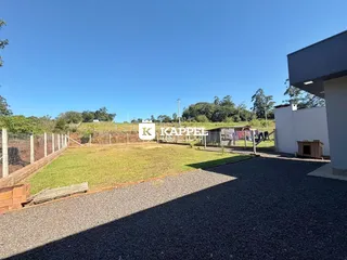 Vista externa de um gramado e área de cascalho em uma propriedade.