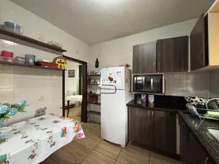 Foto interna de uma cozinha com área de estar e quarto em um imóvel.