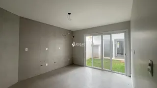 Espaço interno moderno com porta de vidro abrindo para o exterior.