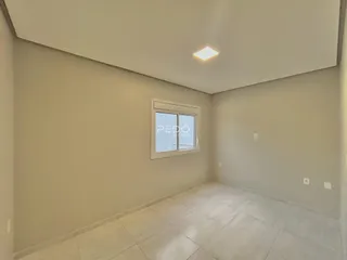 Foto de uma sala interna com paredes claras e piso de cerâmica.