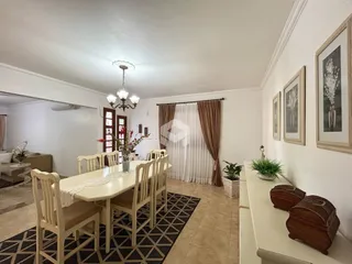 Interior de uma sala de jantar com mesa de madeira e cadeiras em Lajeado.