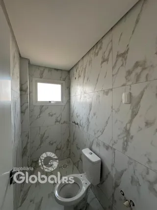 Foto de um banheiro com revestimento de azulejo branco.