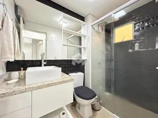 Foto de um banheiro moderno com bancada e box de vidro.