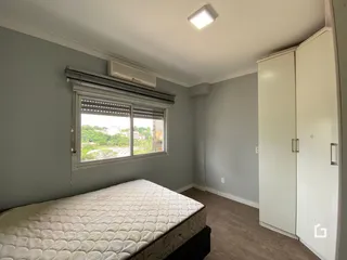 Quarto com janela e cama em sala de estar.