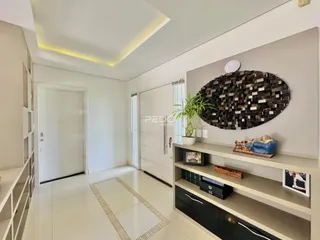 Interior de uma sala com paredes brancas e piso claro.