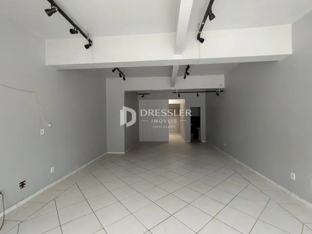 Hall de entrada com piso de cerâmica e paredes brancas.