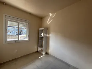Ambiente interno de uma sala com janela e estante.