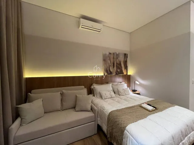 Quarto com cama de casal e sofá branco.
