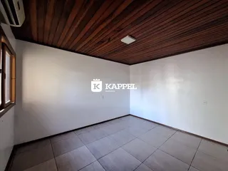 Foto de um ambiente interno com piso de cerâmica e forro de madeira.