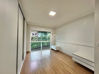 Sala de estar com piso de madeira e porta de vidro que dá para o exterior.