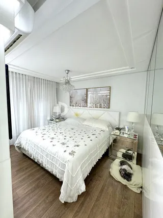 Quarto com cama e cortinas brancas em um imóvel.