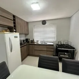 Foto interna de uma cozinha com armários e eletrodomésticos.