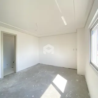Foto de um cômodo vazio com piso de concreto e paredes brancas.
