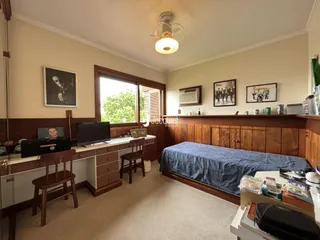 Quarto com cabeceira de madeira e janela em uma sala de estar.