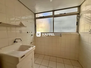 Banheiro com revestimento de azulejos brancos e banheira.