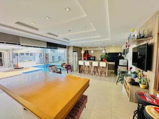 Sala de estar com vista para a área externa e piscina de uma residência.