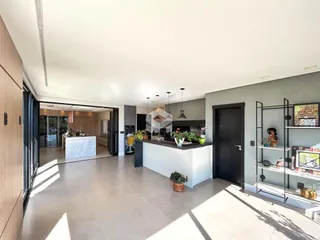 Interior de uma cozinha moderna com ilha e portas de vidro.