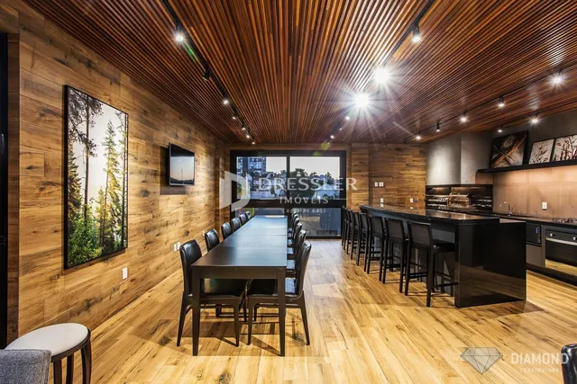 Interior de uma sala de jantar com piso de madeira e teto de madeira no Brasil.