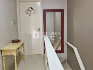 Foto de um corredor interno com uma porta branca e um espelho.
