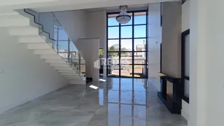 Corredor com escada e portas de vidro grandes em um imóvel.