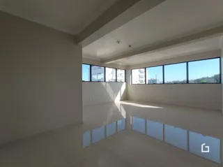 Interior de uma sala de estar com grandes janelas.