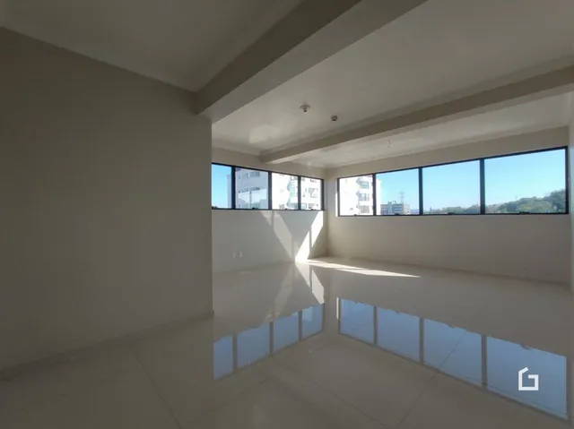 Interior de uma sala de estar com grandes janelas.