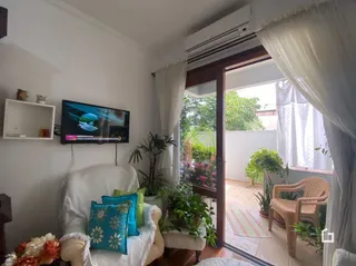 Sala de estar com paredes brancas e porta de vidro abrindo para o exterior.