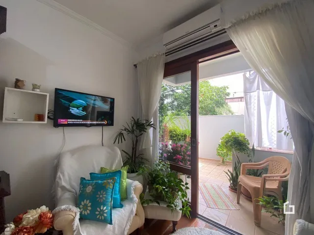 Sala de estar com paredes brancas e porta de vidro abrindo para o exterior.