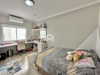 Quarto com cama e escrivaninha em ambiente interno.