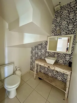 Foto de um banheiro com revestimento de parede em padrão preto e branco.