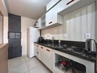 Cozinha moderna com armários brancos e bancada escura.