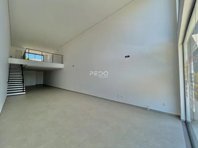 Vista interna de um espaço amplo com piso claro e sacada.