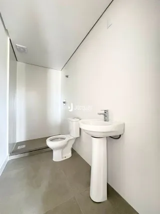 Foto de um banheiro interno com vaso sanitário e pia de pedestal.