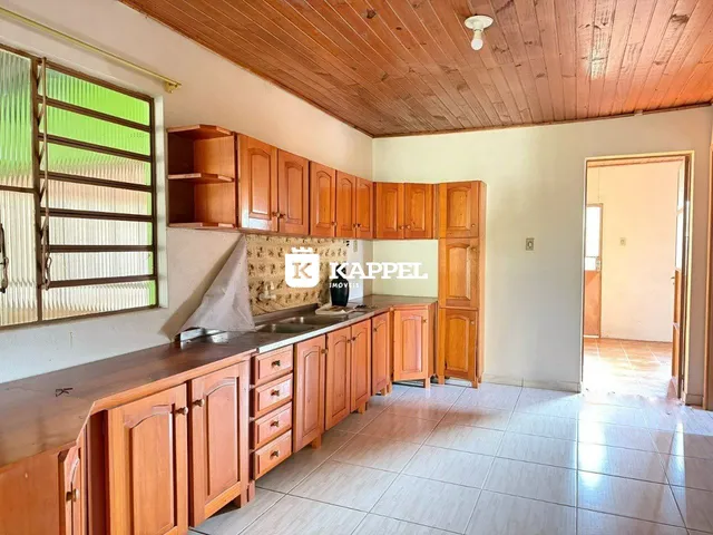 Cozinha com armários de madeira e piso de cerâmica.