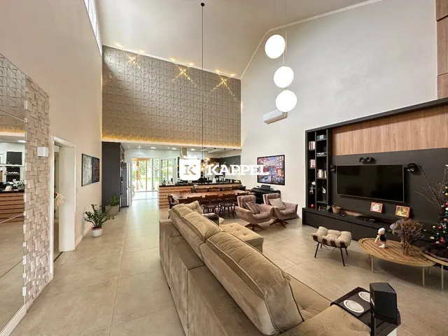 Sala de estar ampla com sofá e área de jantar em um apartamento moderno.