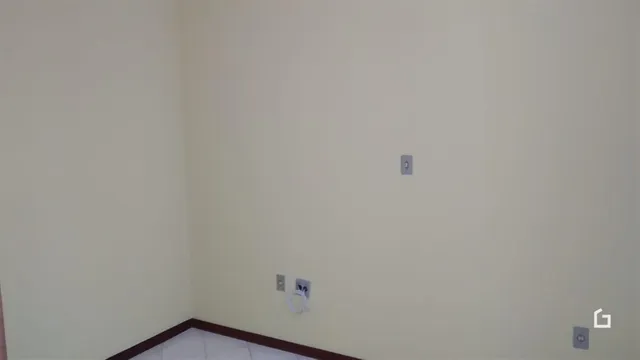 Vista de uma parede interna com rodapé marrom em uma residência.