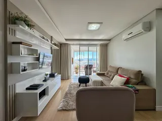 Sala de estar moderna com piso de madeira e vista para o exterior.